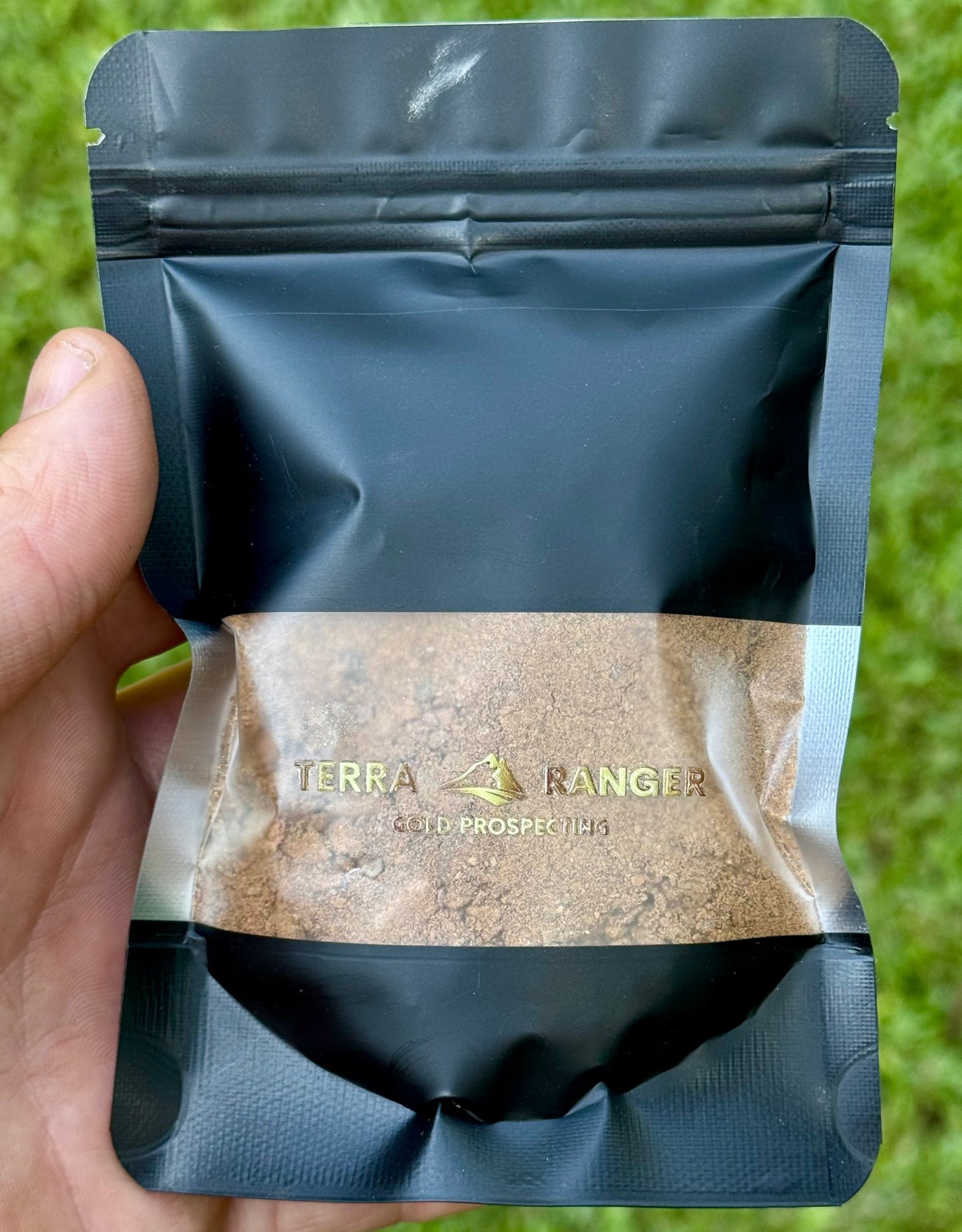 Black zip-lock bag with Terra Ranger paydirt logo on a grass background